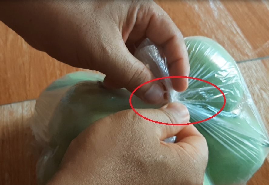 Bước 2: Đẩy phần quai túi lên - Cách cởi nút thắt bọc nilon.